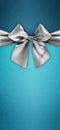 Merry christmas gift card, silver shiny ribbon bow isolated on turquoise glittering background, top view copy space template for