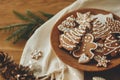 Merry Christmas! Gingerbread cookies with icing in plate on wooden rustic table with fir branches and festive decorations. Royalty Free Stock Photo