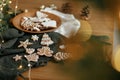 Merry Christmas! Gingerbread cookies with icing in plate on wooden rustic table with fir branches, festive decorations and Royalty Free Stock Photo