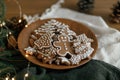 Merry Christmas! Gingerbread cookies with icing in plate on wooden rustic table with fir branches, festive decorations and Royalty Free Stock Photo