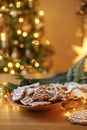 Merry Christmas! Gingerbread cookies with icing in plate on wooden table with fir branches and festive decorations against Royalty Free Stock Photo