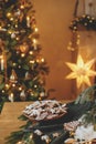 Merry Christmas! Gingerbread cookies with icing in plate on wooden table with fir branches and festive decorations against Royalty Free Stock Photo