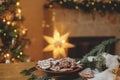 Merry Christmas! Gingerbread cookies with icing in plate on wooden table with fir branches and festive decorations against Royalty Free Stock Photo