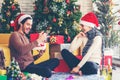 Merry Christmas. girlfriend surprising his boyfriend with Christmas gift. Young couple celebrating and party and drinking champagn