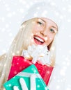 Merry Christmas and glitter snow background, happy blonde girl with gift boxes in winter season for shopping sale and