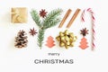Merry Christmas greeting card. Gift box, ribbon, fir branches, cones, star anise, cinnamon, candy cane and paper christmas tree on Royalty Free Stock Photo