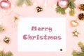 Merry Christmas greeting card with paper, fir tree branches, presents, golden decorations on pink Royalty Free Stock Photo