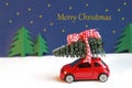 Merry Christmas, greeting card with a christmas tree on a small red car Royalty Free Stock Photo