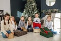 Merry Christmas. Group of children sitting in cozy room after exchanging Xmas presents at fun party Royalty Free Stock Photo