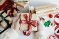 Merry Christmas! Hands wrapping stylish christmas gift. Person preparing modern gift box with red ribbon, golden wrapping paper, Royalty Free Stock Photo
