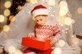 Merry Christmas. Happy child with magic gift near Xmas tree. Royalty Free Stock Photo