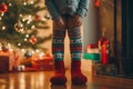 Merry Christmas and Happy Holiday concept. Child feet in Christmas socks over living room with Christmas decoration. Baby feet in