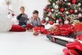 Merry christmas and happy holidays, amazed children near the christmas tree with wrapped gift boxes and musical instruments, in Royalty Free Stock Photo