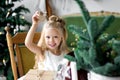 Merry Christmas and Happy Holidays. Cheerful cute child girl opening a Christmas present. Royalty Free Stock Photo