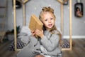 Merry Christmas and Happy Holidays. Cheerful cute child girl opening a Christmas present. Royalty Free Stock Photo