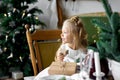 Merry Christmas and Happy Holidays. Cheerful cute child girl opening a Christmas present. Royalty Free Stock Photo