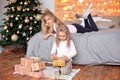 Merry Christmas and Happy Holidays.Cheerful cute children opening gifts. Kids having fun near tree in the morning Royalty Free Stock Photo