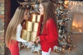 Merry Christmas and Happy Holidays. Cheerful cute kid girls opening gifts. Children near the tree in the morning. Royalty Free Stock Photo