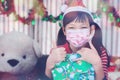 Merry Christmas and Happy Holidays! Cheerful cute little girl in mask exchanging gifts, small children having fun in the house Royalty Free Stock Photo