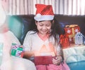 Merry Christmas and Happy Holidays! Cheerful cute little girl open box and exchanging gifts, small children having fun in the Royalty Free Stock Photo