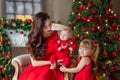 Merry Christmas and Happy Holidays Cheerful mom and her cute daughter girl exchanging gifts. Parent and little child having fun Royalty Free Stock Photo