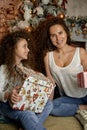 Merry Christmas and Happy Holidays Cheerful mom and her cute daughter girl exchanging gifts. Parent and little child Royalty Free Stock Photo