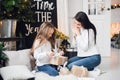 Merry Christmas and Happy Holidays. Cheerful mom and her cute daughter girl opening a Christmas present. Parent and Royalty Free Stock Photo