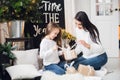 Merry Christmas and Happy Holidays! Cheerful mom and her cute daughter girl opening a Christmas present. Parent and Royalty Free Stock Photo