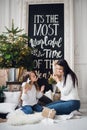 Merry Christmas and Happy Holidays. Cheerful mom and her cute daughter girl opening a Christmas present. Parent and Royalty Free Stock Photo