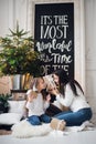 Merry Christmas and Happy Holidays. Cheerful mom and her cute daughter girl opening a Christmas present. Parent and Royalty Free Stock Photo