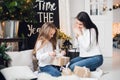 Merry Christmas and Happy Holidays. Cheerful mom and her cute daughter girl opening a Christmas present. Parent and Royalty Free Stock Photo