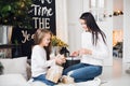 Merry Christmas and Happy Holidays. Cheerful mom and her cute daughter girl opening a Christmas present. Parent and Royalty Free Stock Photo