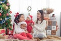 Merry Christmas and Happy Holidays! Cheerful mom and her cute daughters playing and have fun together