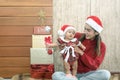 Merry Christmas and Happy Holidays! Cheerful mom and her cute 6 months daughter playing and have fun together