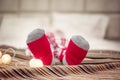 Merry Christmas and Happy Holidays. Child feet in red socks lying on bed. Festive light garland background