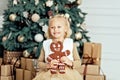 Child girl eating iced sugar cookies under Christmas tree Waiting for Christmas. Royalty Free Stock Photo