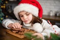 Merry Christmas and Happy Holidays. Cute child girl eating ginger cookies. Royalty Free Stock Photo