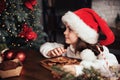 Merry Christmas and Happy Holidays. Cute child girl eating ginger cookies. Royalty Free Stock Photo