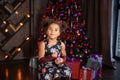 happy little child with gifts and Christmas tree and lights