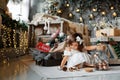 Merry Christmas and Happy Holidays. A cute little girl is decorating a Christmas tree indoors. Happy little smiling girl with Royalty Free Stock Photo