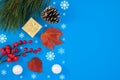 Merry Christmas and Happy Holidays greeting card, frame, banner, pine cone and decorative snowballs on blue background, top view. Royalty Free Stock Photo