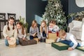 Merry Christmas. Group of children sitting in cozy room after exchanging Xmas presents at fun party Royalty Free Stock Photo