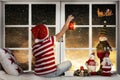 Merry Christmas . Little boy sitting on the window and looking at Santa Claus flying in his sleigh against moon sky. Royalty Free Stock Photo