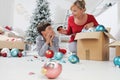 Merry Christmas and Happy Holidays! Mom and son decorate the Christmas tree in the house. accidentally the child breaks the balls Royalty Free Stock Photo