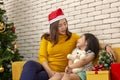 Merry Christmas and Happy Holidays or Happy New Year Mother gave a gift to a cute girl. The girl hugs the teddy bear that the Royalty Free Stock Photo