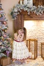 Merry Christmas and happy holidays! New Year 2020. Portrait of a cute little girl decorates a Christmas tree in the living room wi Royalty Free Stock Photo