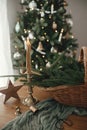 Merry Christmas and Happy holidays! Stylish rustic basket with fir branches, vintage candle and wooden star on table against Royalty Free Stock Photo