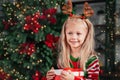 Merry Christmas and Happy Holidays. Surprised cute child girl opening present. Royalty Free Stock Photo