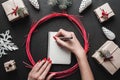 Merry Christmas and Happy Holidays! Woman hands with bright red nails writing letter with silver pen. Royalty Free Stock Photo