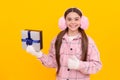 merry christmas. happy kid in winter earmuffs with box. teen girl in mittens